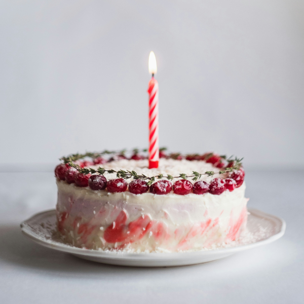 eine Geburtstagtorte mit einer brennenden Kerze